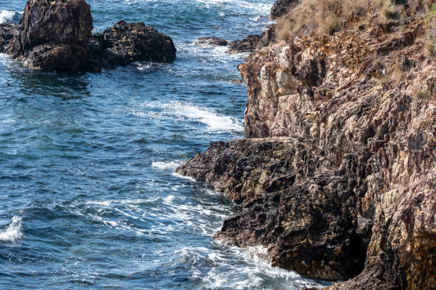 distant shot with cliff cliffs and sea wave on a mediterranean island,slow motion