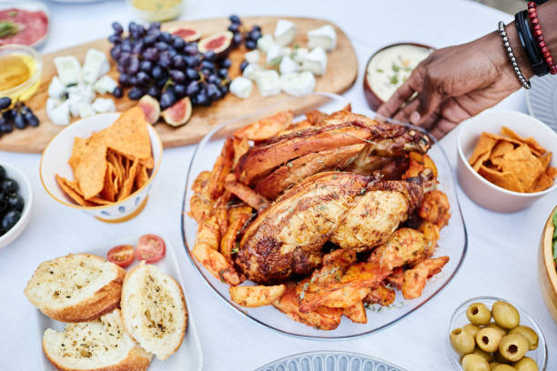 istock Close Up of Black Man Putting Roasted Chicken Dish on Table 2181572701