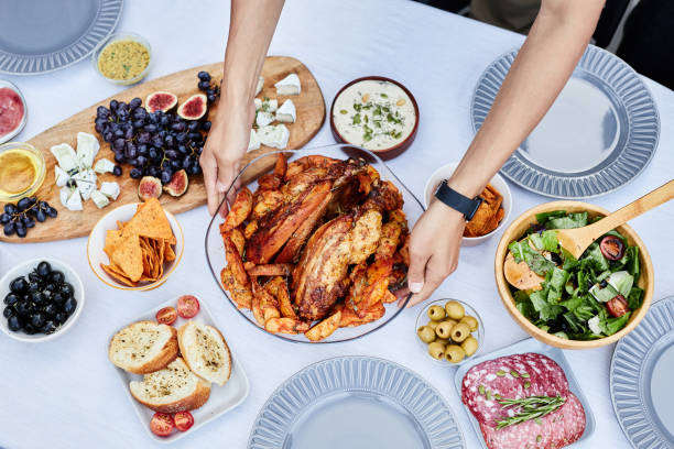 Male Hands Putting Roasted Chicken on Dinner Table