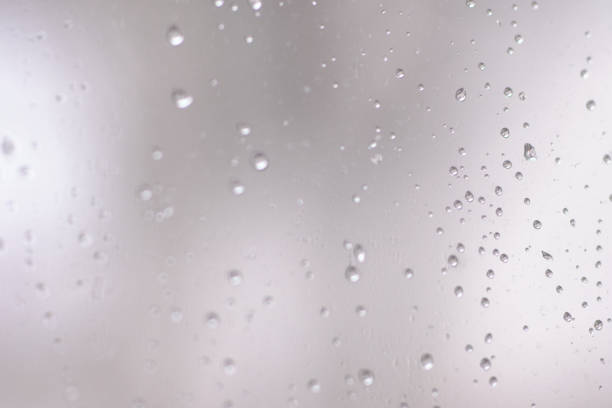Water drops on window glass in macro shot in slow motion