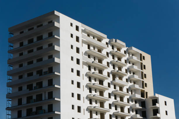 istock Block of flats under construction with a white facade. Raw apartment building structure without windows. 2181575670