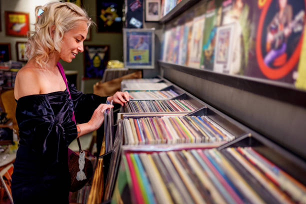 istock Young woman browsing vinyl records in a retro-style record store. 2181576290