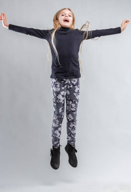istock Enthusiastic girl jumping with open arms and excitement 2181576579