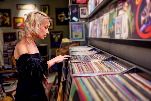 istock Young woman browsing vinyl records in a retro-style record store. 2181577079