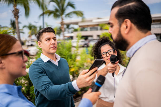 istock Journalists interviewing man outdoors 2181581790