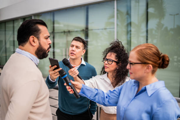 istock Journalists interviewing man outdoors 2181581791
