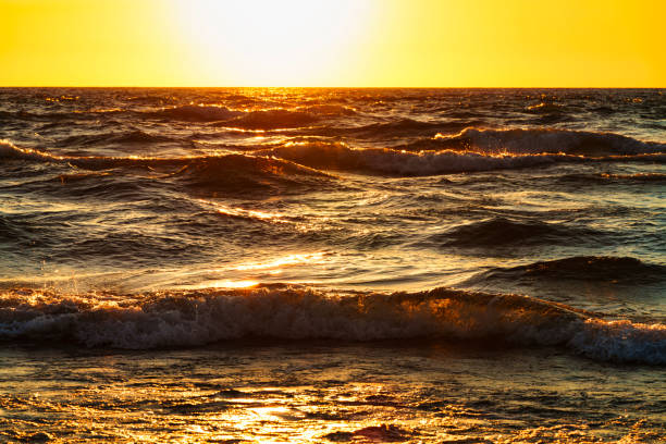 Waves at Sunset Lake Michigan - Looking west into warm sunset sunlight along the coast of Michigan, USA.