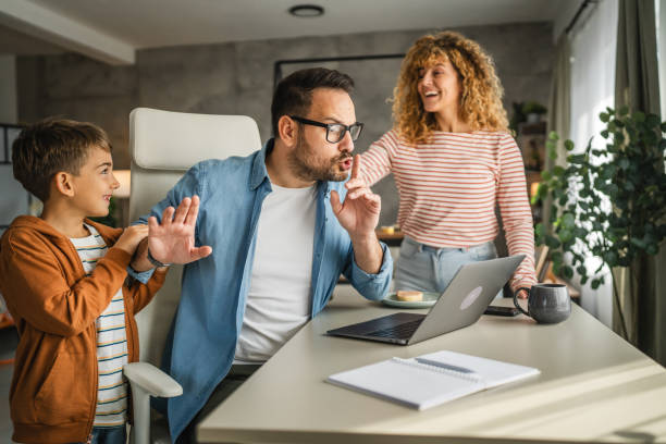 istock the father try to work from home while his family distracts him 2181588612
