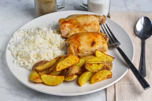 istock chicken thighs  with rice and  potatoe wedges 2181589128