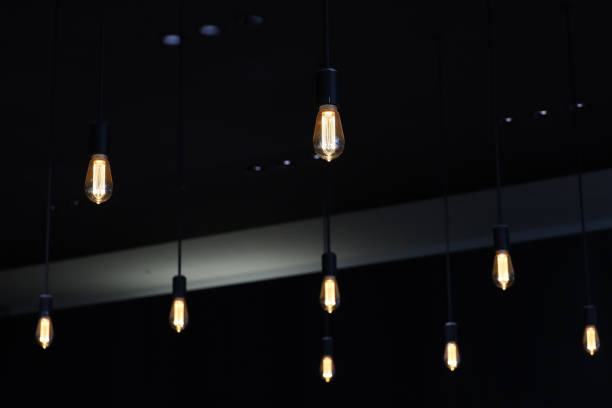 istock Several simply designed pendant lights hanging from the ceiling in a dimly lit room 2181589129