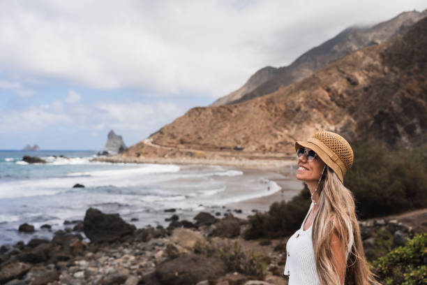 istock A woman enjoys the coastal scenery at a remote beach while wearing a hat 2181591455
