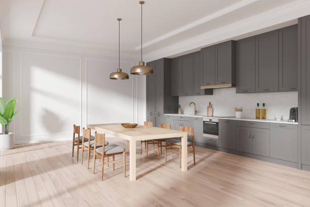 istock Modern kitchen interior with grey cabinets, wooden dining table and chairs, pendant lights, and potted plant. Bright room, clean, luxury home decor. 3D Rendering 2181591780