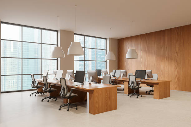 istock Office coworking interior with pc monitors on desks in row, panoramic window 2181591936