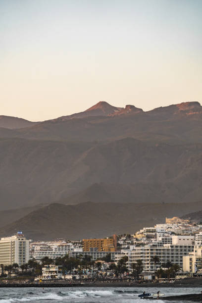 istock Sunset over coastal town with mountains in the background, capturing the serene 2181593064