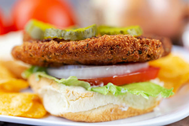Breaded pork tenderloin sandwich with lettuce, tomato, onion, pickles and mayo.