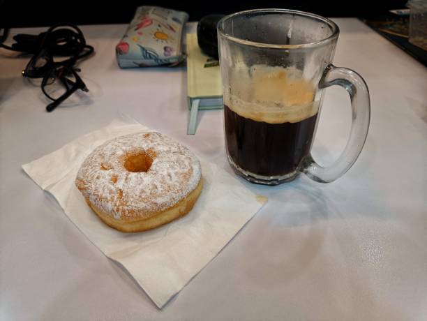 istock Donuts and black coffee as breakfast at the desk 2181617828