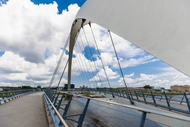 istock Connecting urban districts with modern engineering in capital cities. Cable-stayed pedestrian Women of Achievement Bridge spans Des Moines River under dramatic sky. 2181626706