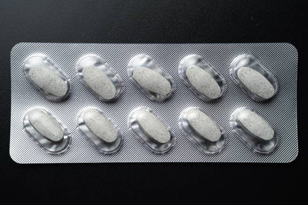 Tablet white pills blister Medicine capsules on a black background