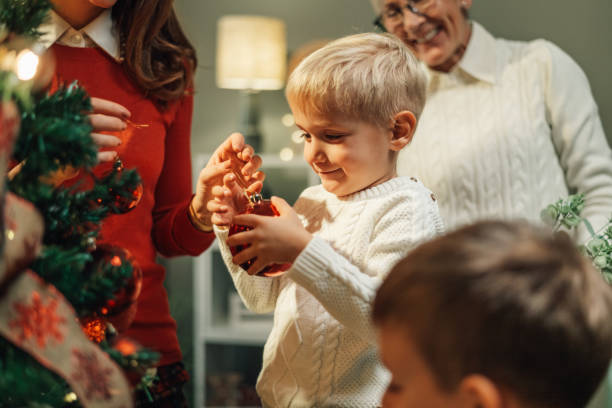 istock Happy family is decorating christmas tree at home 2181636350