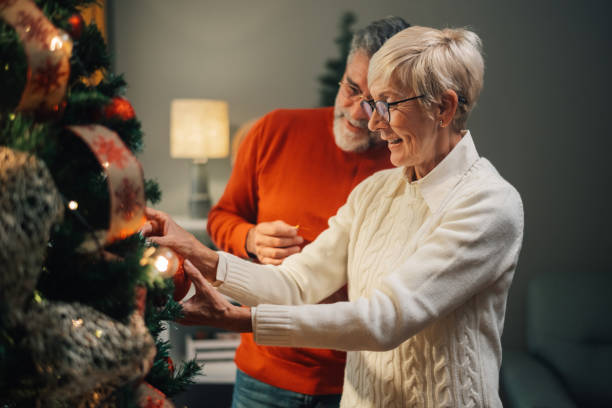 istock Senior couple decorating christmas tree at home 2181636381