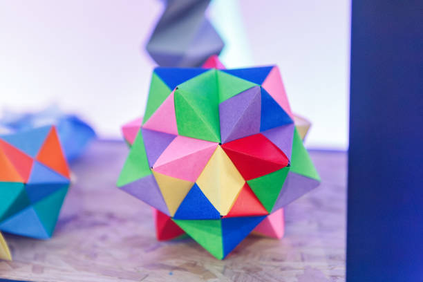 Close-up of origami cube in different colors with spikes against gray background. Photo taken February 26th, 2025, Zurich, Switzerland.