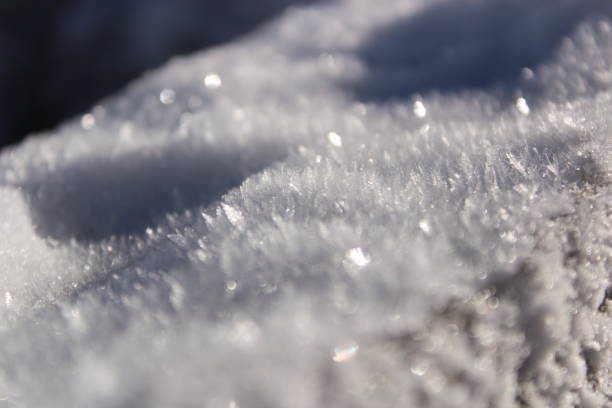 Close of shot of fresh snowflakes on a wooden rail.