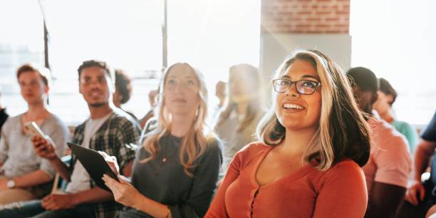 gruppo eterogeneo di persone, tra cui una donna sorridente, che partecipa al seminario. - allenamento foto e immagini stock