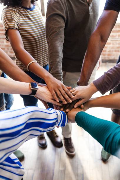 istock Diverse group of people joining hands in unity. 2181647187