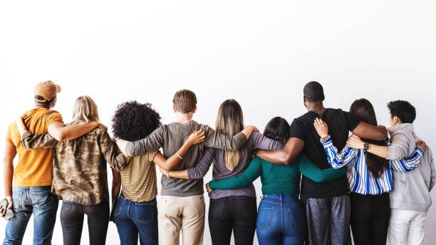 istock Diverse group of people standing hugging, embracing each other facing away. 2181647192