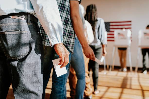 istock Diverse people in line voting in election, holding ballots. 2181647691