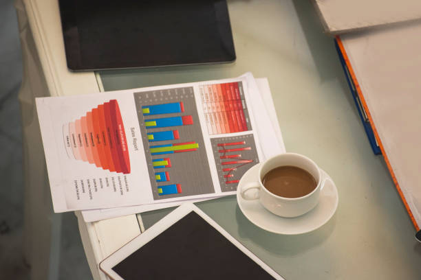 Office laptop business financial document chart and graph on wooden table with coffee cup. Flat lay notebook computer laptop on office desk. No people business graph chart mockup on business workspace