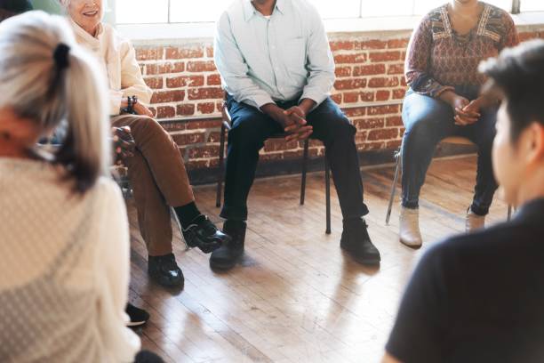 istock A diverse group of people sitting in a circle, engaged in discussion, with a focus on community and connection in a bright room. 2181651248