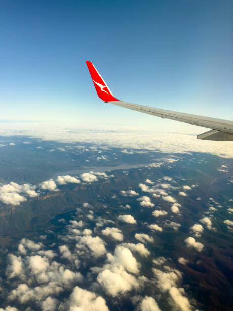 NEW SOUTH WALES, AUSTRALIA - OCTOBER 12 2022: A Qantas plane with wing tips flies over The Blue Mountains near Sydney on a clear day