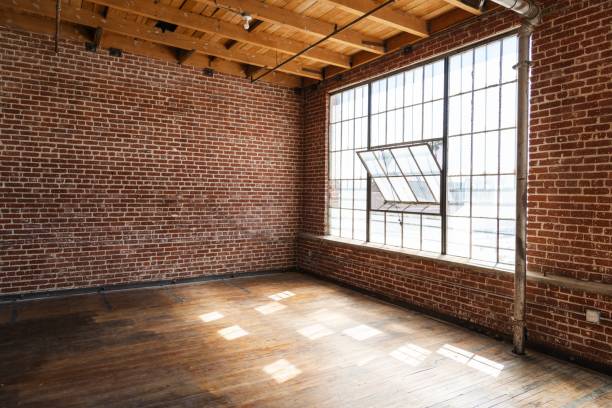 istock Spacious loft with exposed brick walls, large windows, and wooden floors. 2181651418