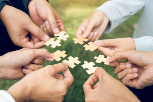 istock group of business people assembling jigsaw puzzle. The concept of cooperation, teamwork, help and support in business. 2181656635
