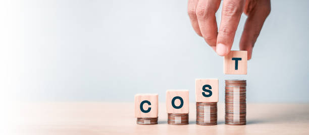 istock Cost reduction concept. Cost wording on decreasing coins stacking. cost reduction concept which effect to product cost , profit , inflation and economy recession concept. 2181661604