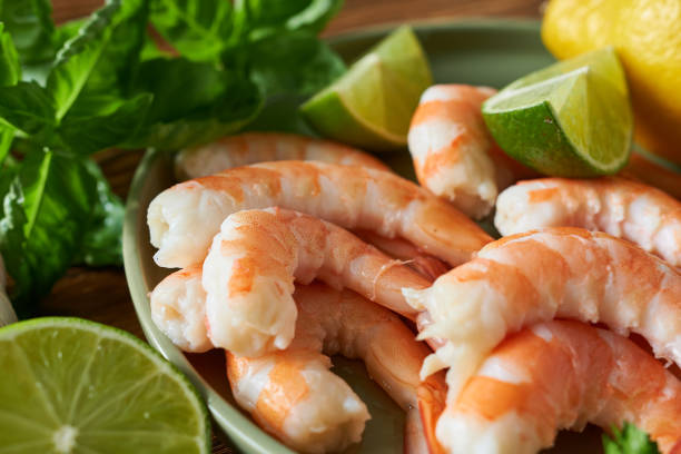 istock Shrimps with lime slices on wooden table, closeup view 2181662806