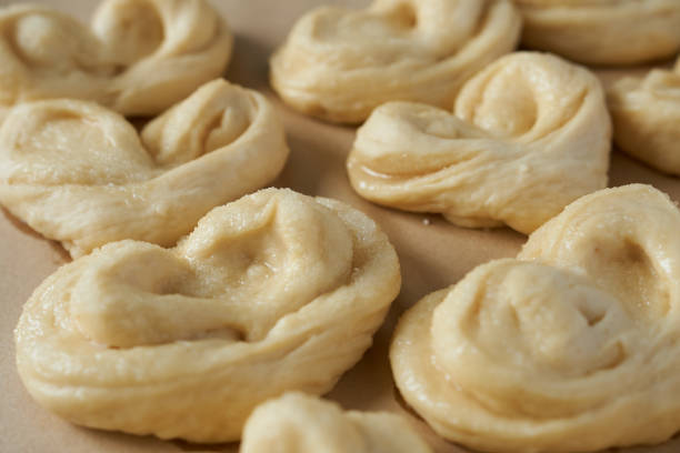 Close-up of raw buns on baking paper. Selective focus.