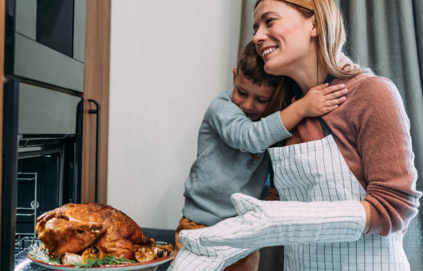 istock Mother and son preparing turkey for Thanksgiving day. 2181662990