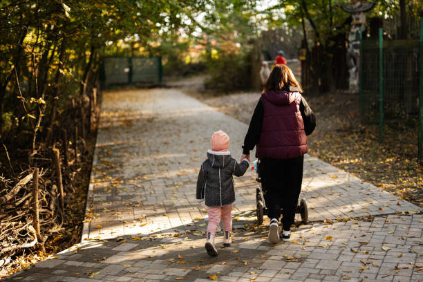 istock Mother and child walking with a stroller on a sunny autumn day 2181664233