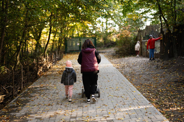 istock Mother and child strolling through a peaceful autumn forest path 2181664235