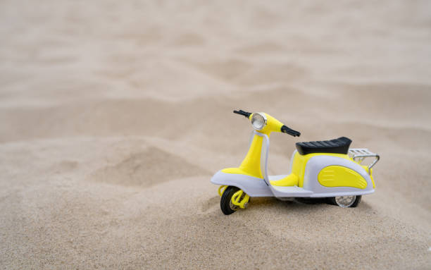 Small child scooter stands on white sand. Summer vacation. Postcard. Still life. Copy space.