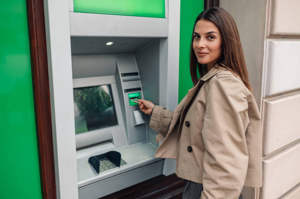 istock Young woman withdrawing money from atm 2181666175