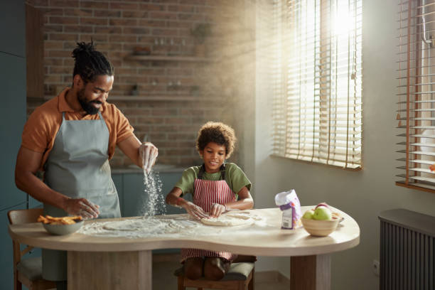 istock Happy black father and son making pizza in the kitchen. 2181667551