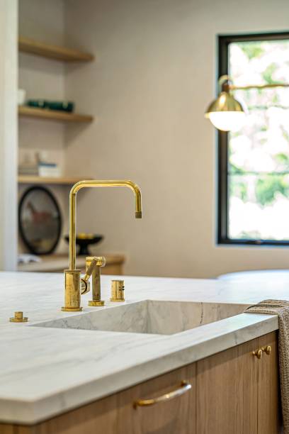 istock Modern kitchen with marble countertop and gold faucet. 2181669246