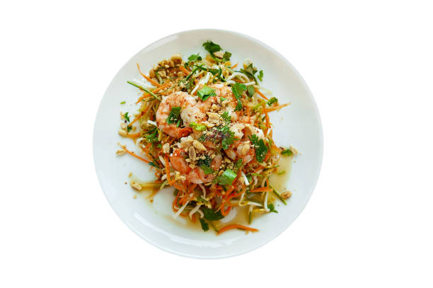 Vietnamese vegetable salad with shrimps in a white plate. Top view. White background isolated.