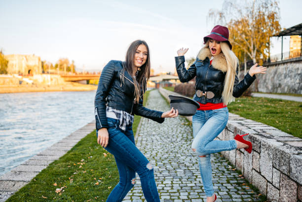 Two female friends playing around on the quayside.