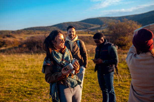 istock Group of smiling friends having fun on hill peak at sunset. 2181688581