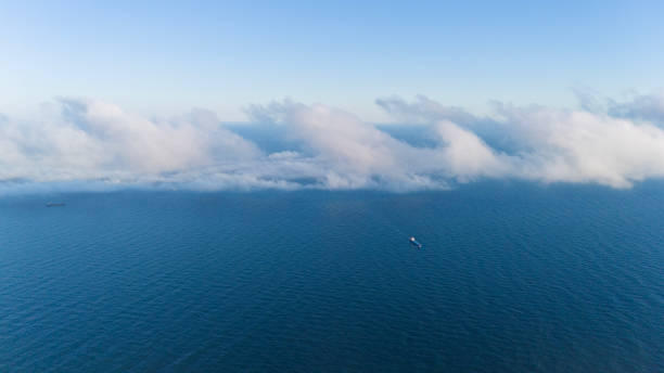 Aerial view of Cargo ship under clouds. Clouds over sea.