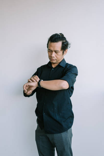 istock Southeast Asian man checking his watch, focused and attentive 2181689385